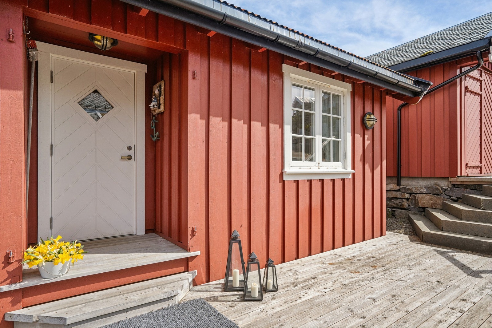 Malt hovedytterdør og stående bordkledning på fasaden. Rorbua er fundamentert på impregnerte påler festet under vann. Galleribilde