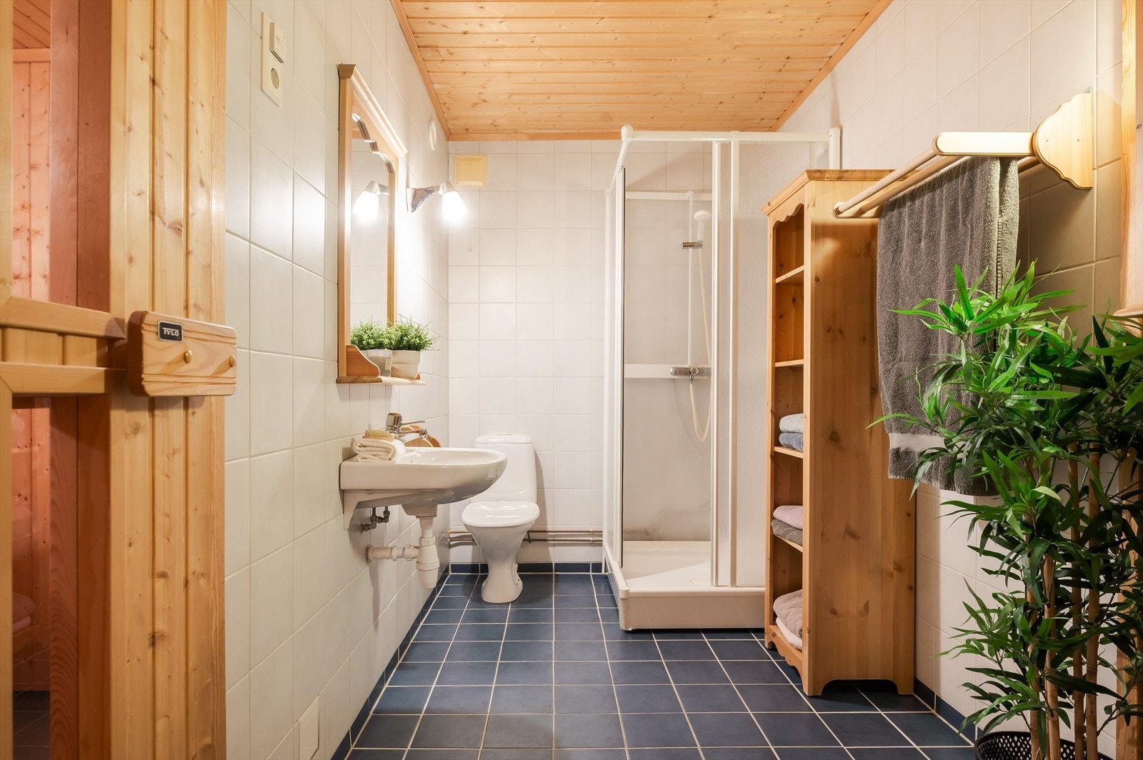 Flislagt bad i kjeller med varmekabler i gulvet. Badet har dusjkabinett, gulvmontert toalett og vegghengt servant. Galleribilde