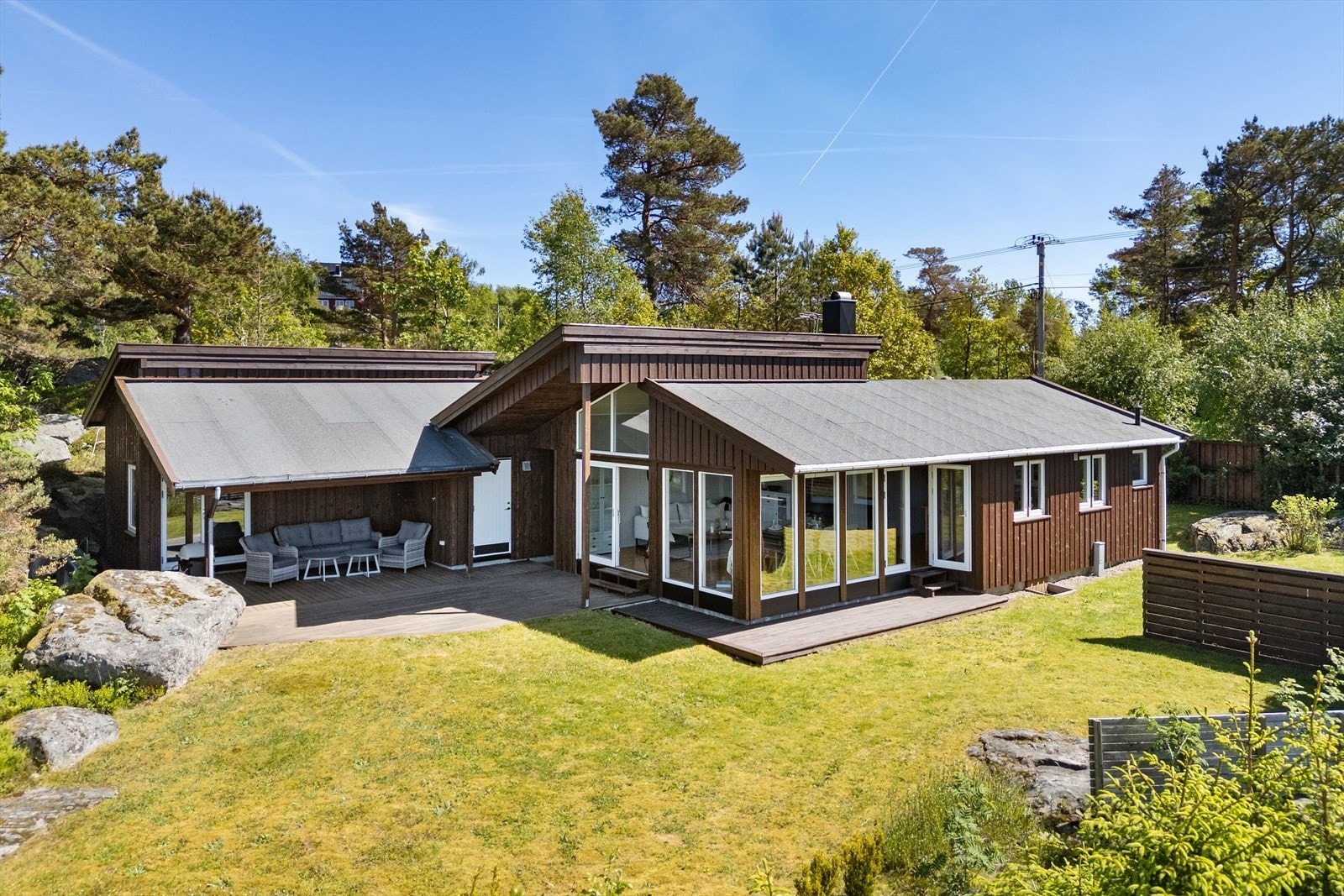 Hytta ligger fint til i terrenget, omkranset av natur Galleribilde