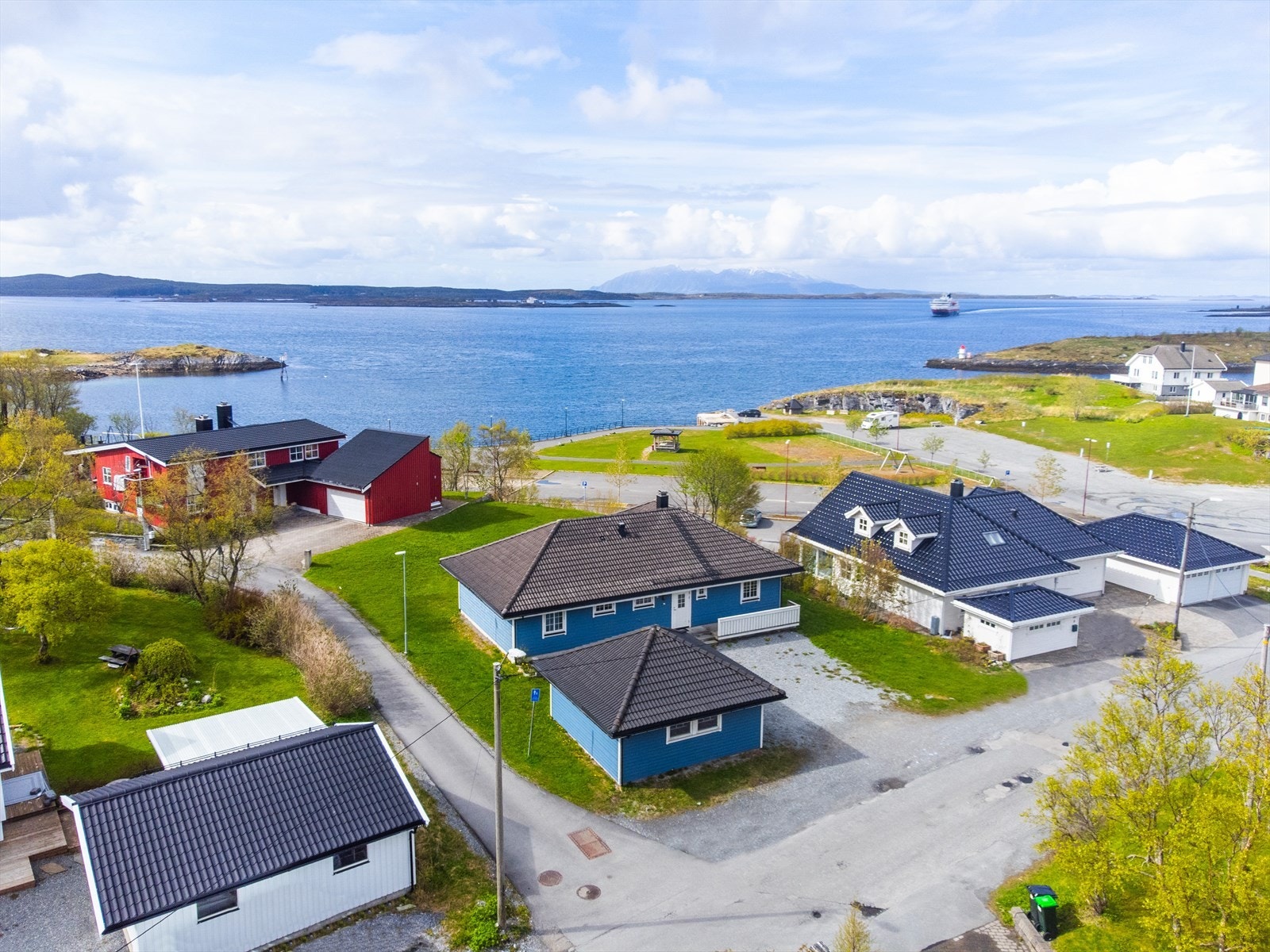 Eiendommen ligger på en lett kupert tomt med opparbeidet plen og gruset gårdsplass. Galleribilde