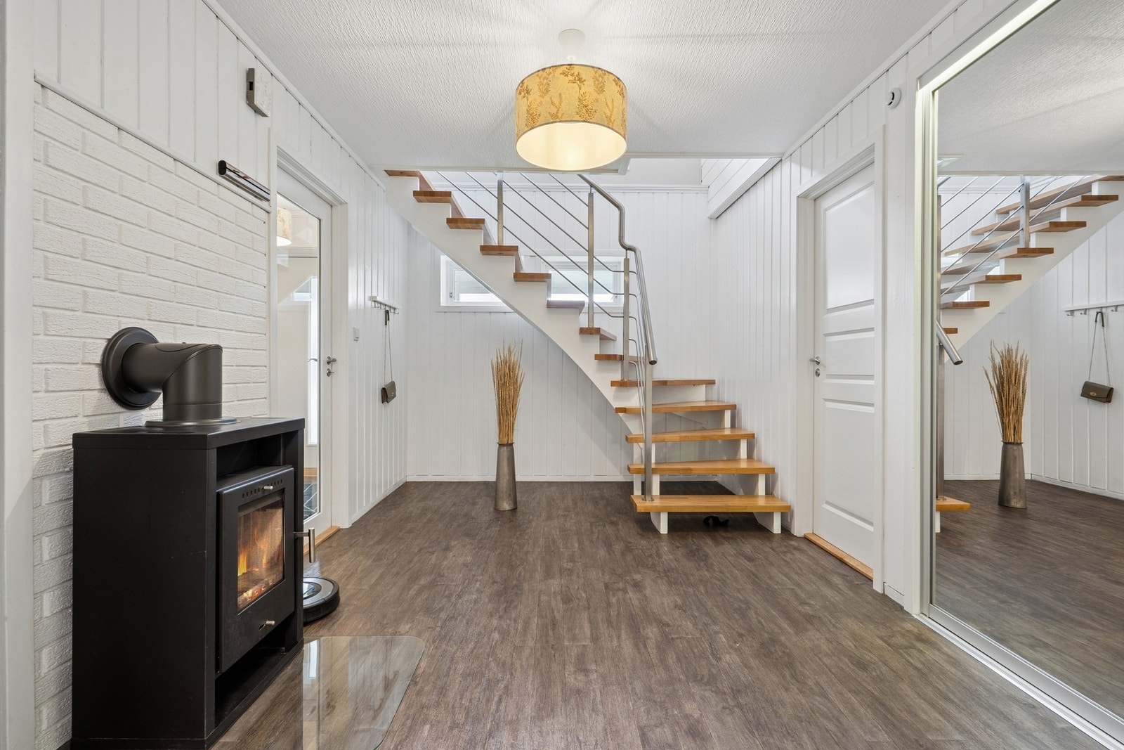 Lakkert tretrapp med rekkverk av metall binder de to etasjene sammen. Galleribilde