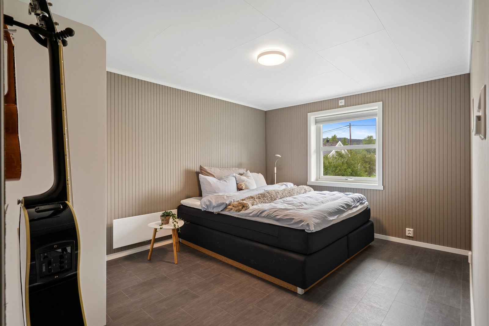 Rom i sokkeletasjen med panel på veggene og laminat på gulvet. Galleribilde