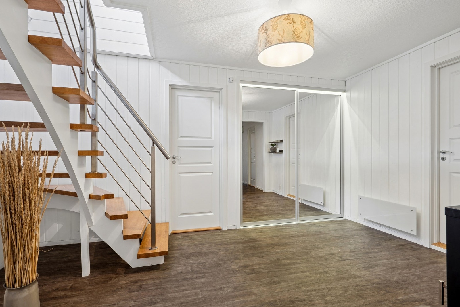 Entré med skyvedørsgarderobe og trapp opp til første etasje. Boligen har sentralstøvsuger. Galleribilde
