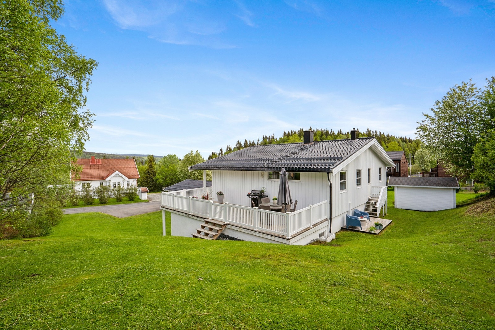 Eiendommen har en opparbeidet tomt med plenarealer og ligger i et relativt flatt terreng. Galleribilde
