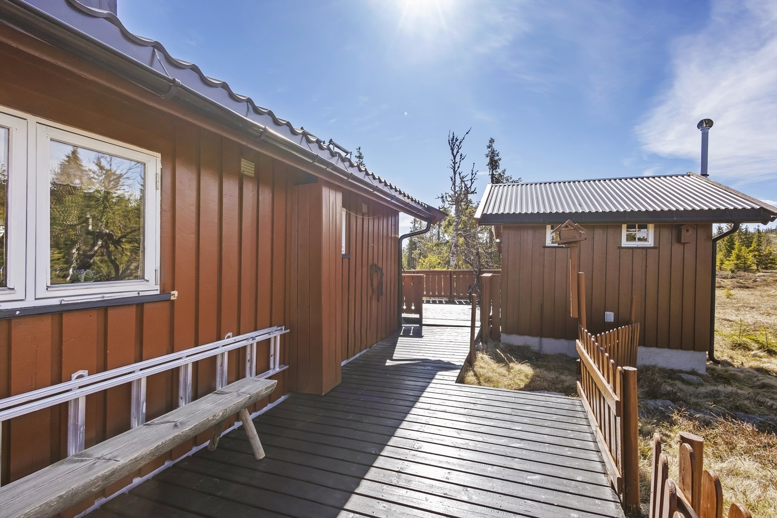 Terrassen forbinder hovedhytta med et uthus som inneholder bod og toalettrom. Galleribilde