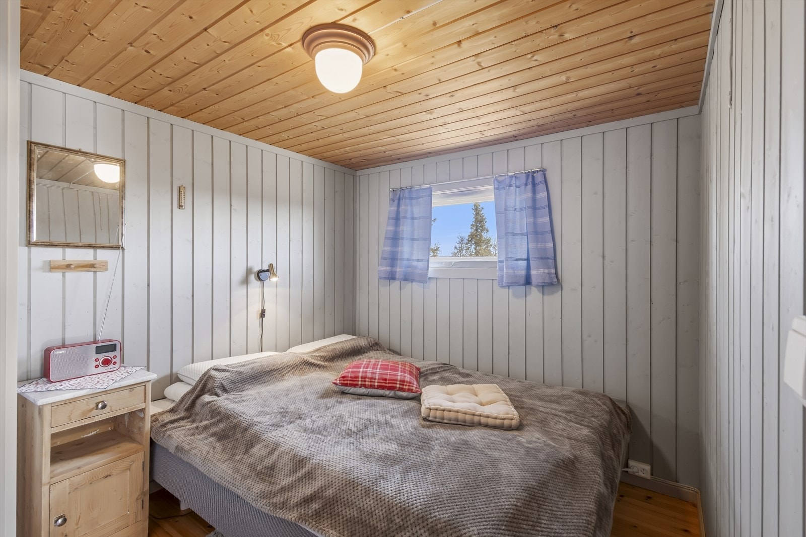 Det andre soverommet har også tregulv og panel, med vindu som gir naturlig lys. Galleribilde