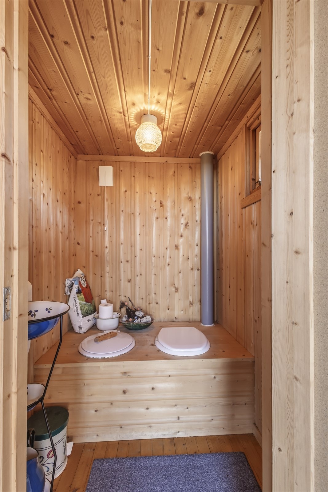 Uthuset har et separat toalettrom med panelkledde overflater. Galleribilde