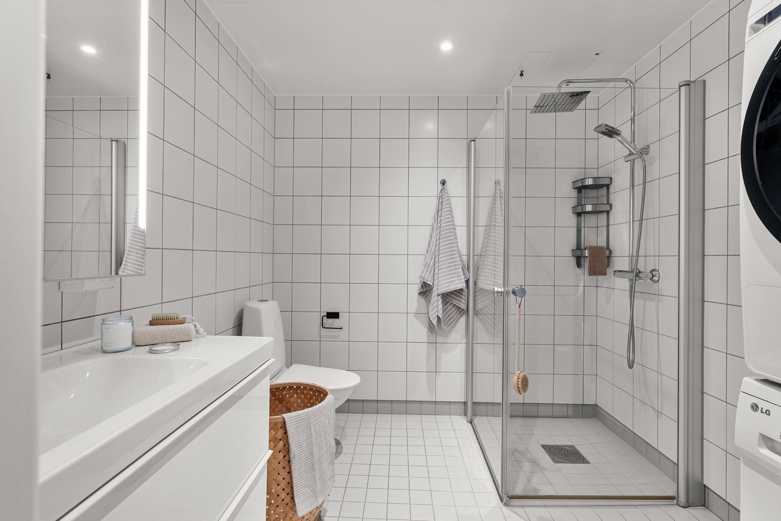 - Badet er innredet med heldekkende servant, vegghengt toalett, dusjdører i glass og opplegg for vaskemaskin - Galleribilde
