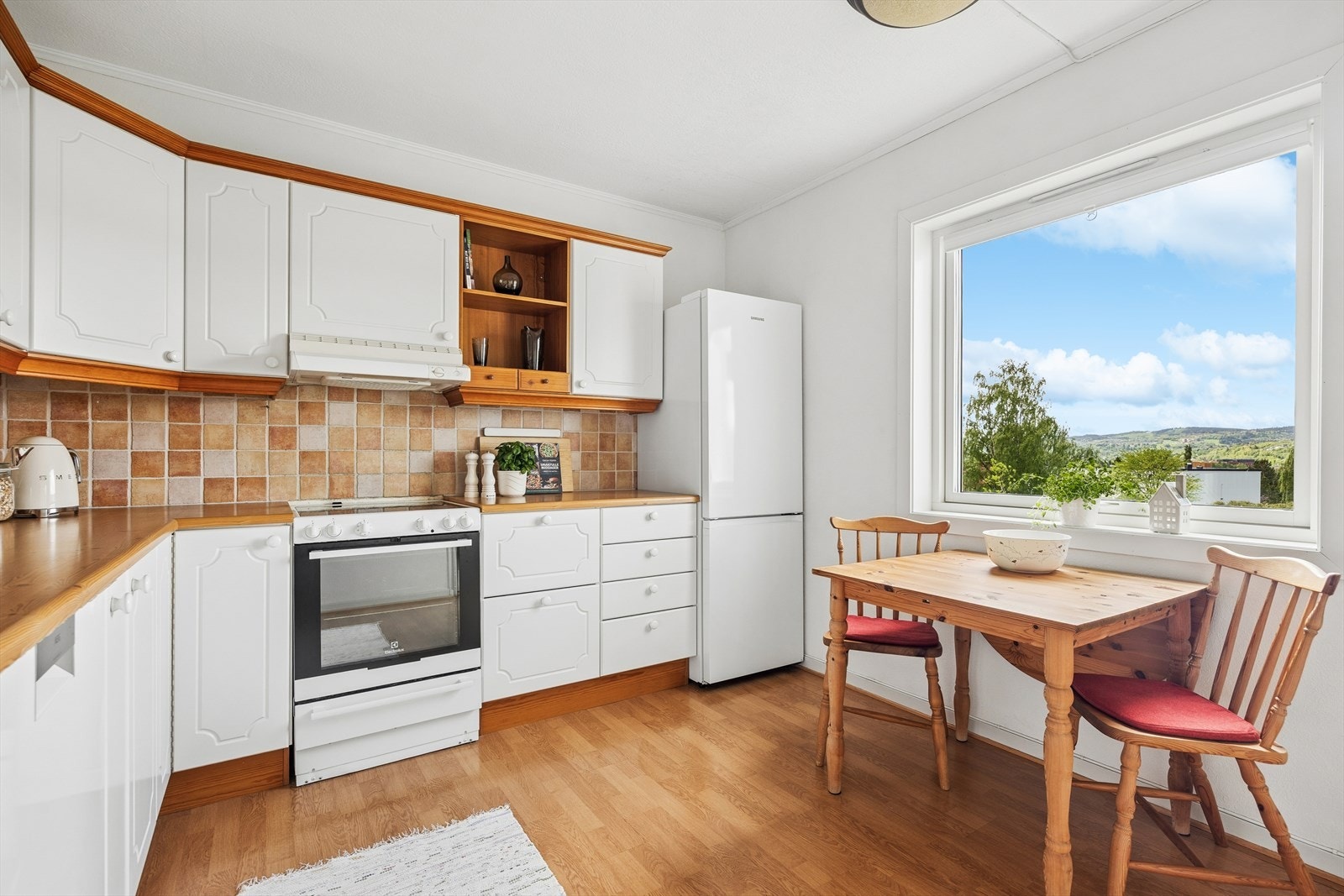 Innredningen har klassiske profilerte fronter, og det er naturlig plass til et hyggelig frokostbord ved vinduet. Galleribilde