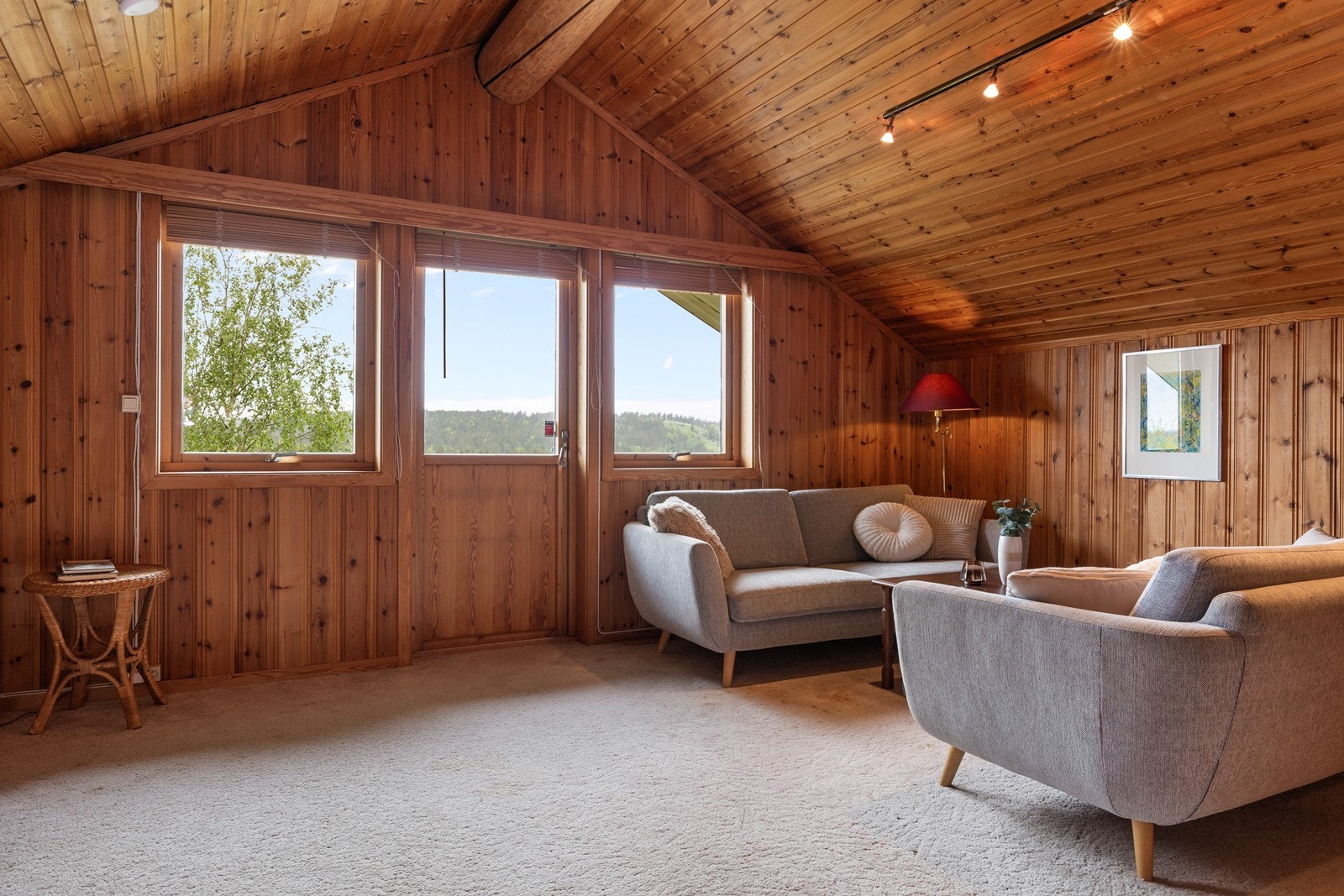 Loftstuen i andre etasje har trepanel på vegger og i himling, og utgang til en veranda. Galleribilde
