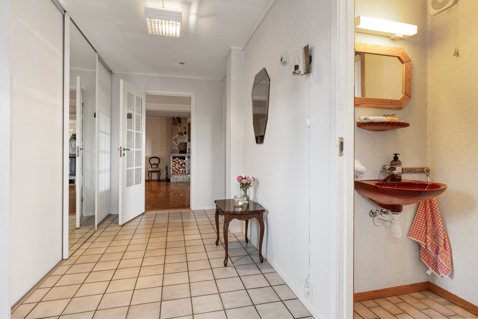 Entréen i sokkelleiligheten har flislagt gulv og skyvedørsgarderobe. Galleribilde