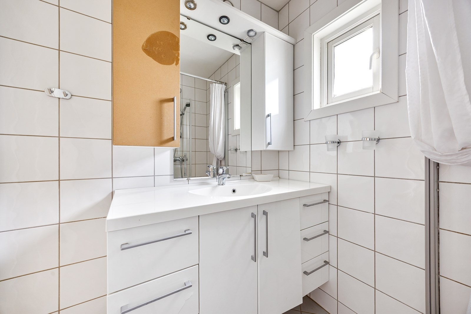 Badet har flislagte vegger og gulv, samt malte plater i himling. Galleribilde