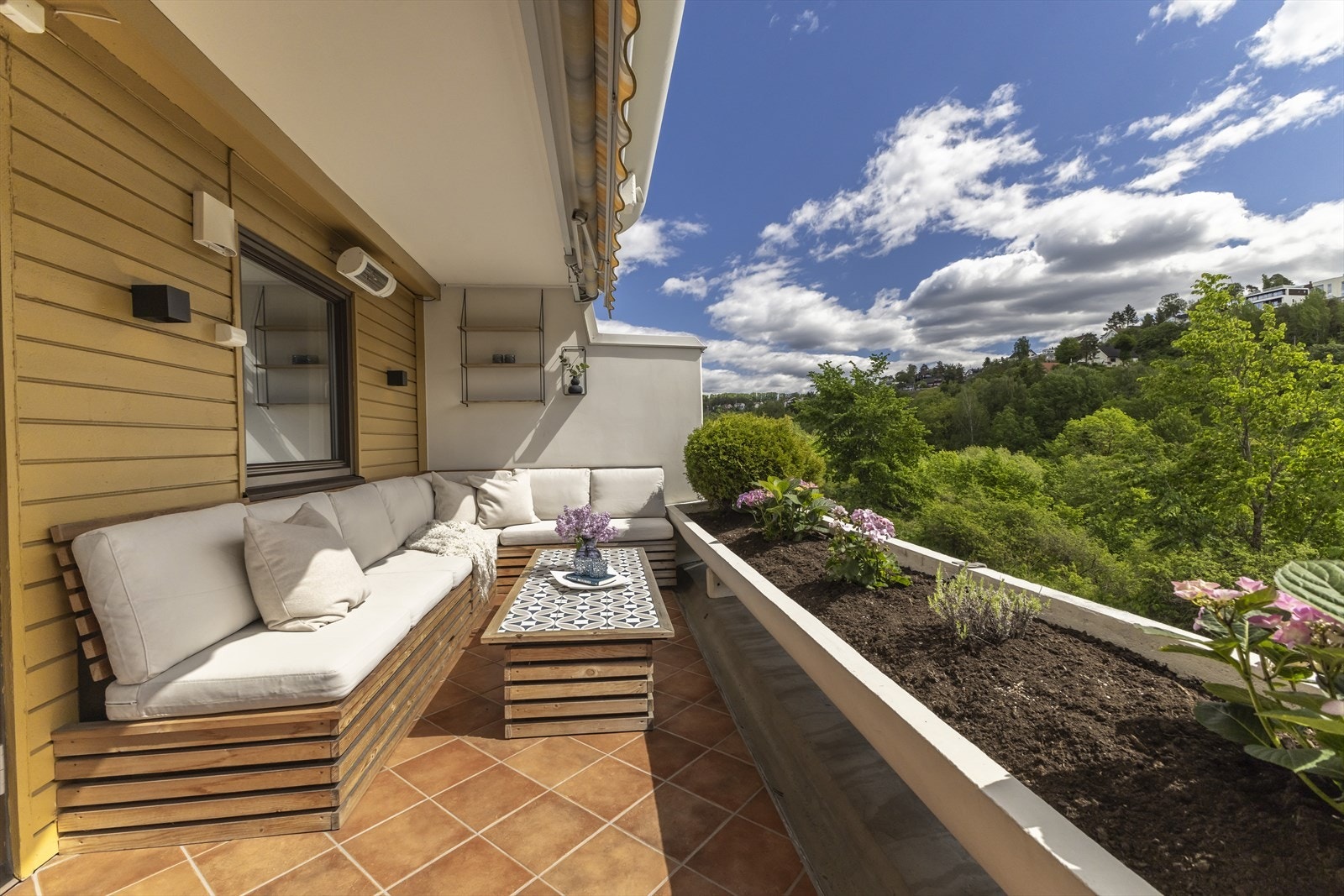 Fra stuen åpnes dørene ut mot en fantastisk terrasse på ca. 12 kvm som fungerer som en naturlig forlengelse av oppholdsrommet. Hjørnesofaen på terrassen er plassbygget og medfølger i handelen. Sittedelen har luker som gir godt med lagringsplass. Galleribilde