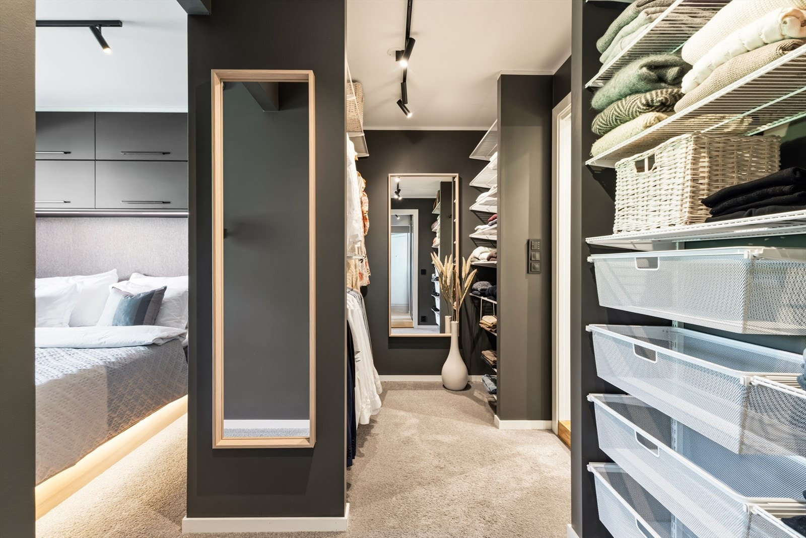 Den romslige walk in garderoben gir svært gode oppbevaringsmuligheter og binder master bedroom og baderom sammen på en elegant måte. Det fleksible fra Elfa gir gode muligheter for individuell tilpasning og kan enkelt justeres etter behov over tid. Galleribilde