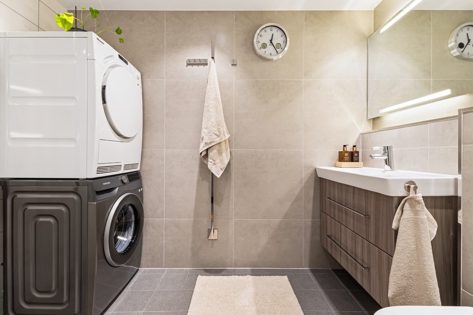 Det private baderommet tilknyttet master bedroom har et moderne uttrykk med flislagte overflater, behagelige varmekabler og praktisk innredning. Elektrisk håndkletørker er montert på vegg. Galleribilde