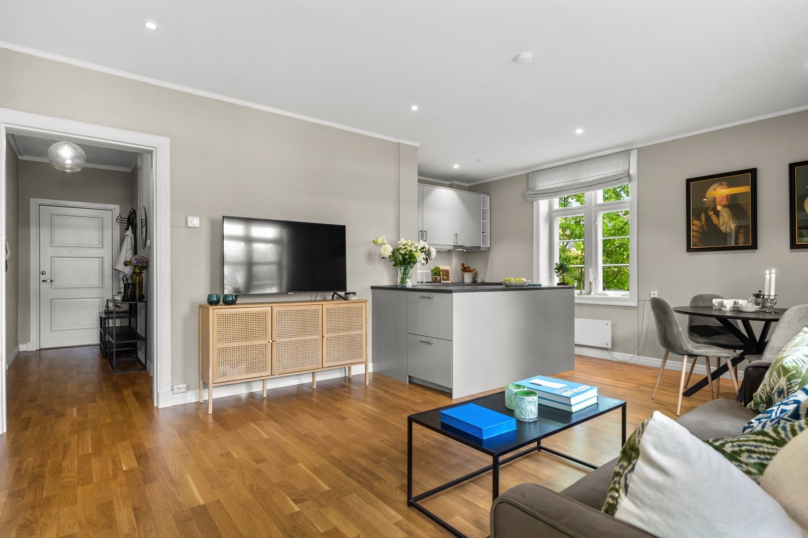 Stor stue med åpen kjøkkenløsning, nedsenket himling med downlights og eikeparkett på gulv. Galleribilde