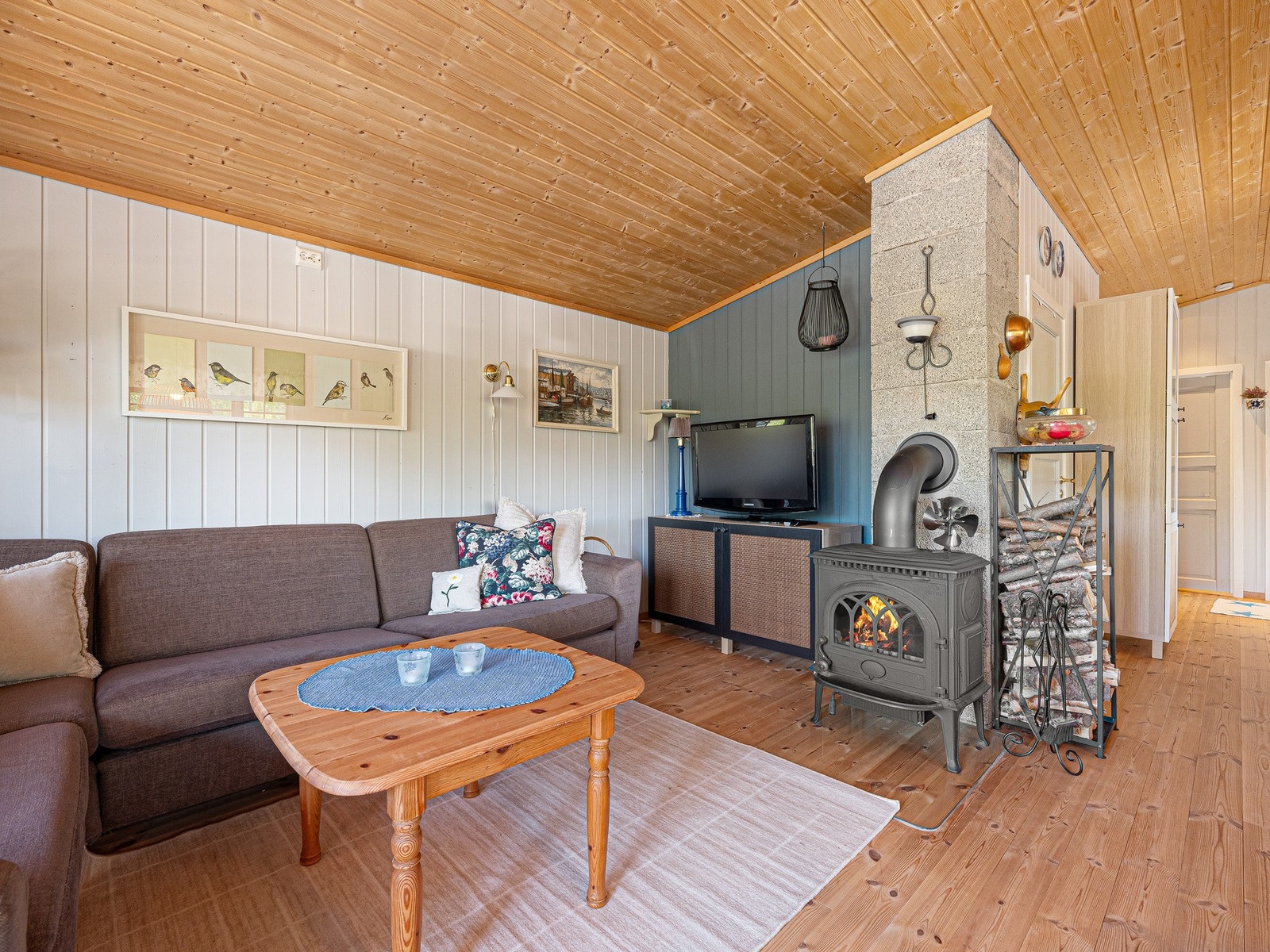 Hytta har et klassisk og koselig preg, med trepanel, lyse flater og en planløsning som gjør oppholdsrommet enkelt å møblere. Galleribilde