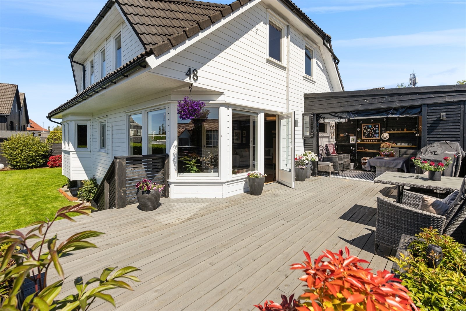 Det er etablert flere uteplasser med treterrasser på eiendommen. Her ser vi den solrike terrassen med utgang fra stuen. En hyggelig hagestue med plasttak og spilevegg, bygget i 2022, ikke omsøkt. Galleribilde