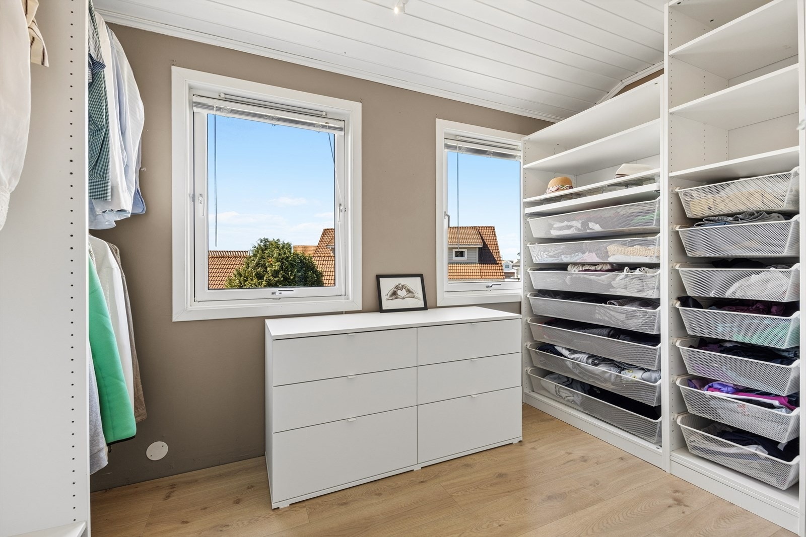 Walk-in garderobe med god plass til klær og tilbehør. Rommet har to vinduer og innredning med hyller og hengestenger. Rom innredet (ikke omsøkt). Garderobedelen er del av den ikke-godkjente ombyggingen fra loftstue. Galleribilde