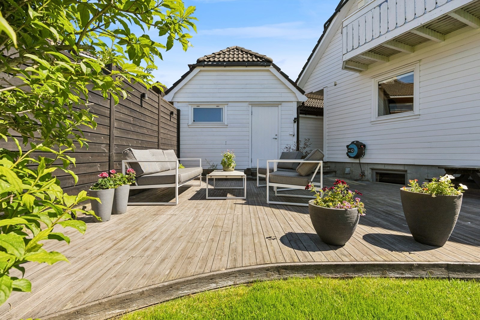 Terrasse på bakkeplan ved garasjen. Her kan man enkelt flytte seg etter solen - eller finne en sval plass i skyggen! Galleribilde