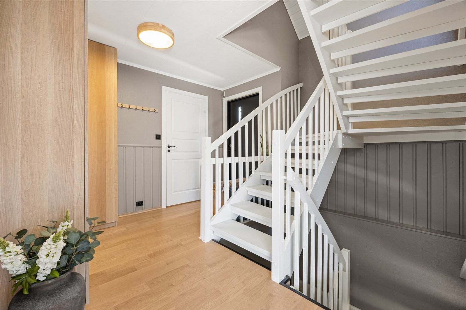 Den malte tretrappen binder etasjene sammen og er et sentralt element i boligen. Galleribilde