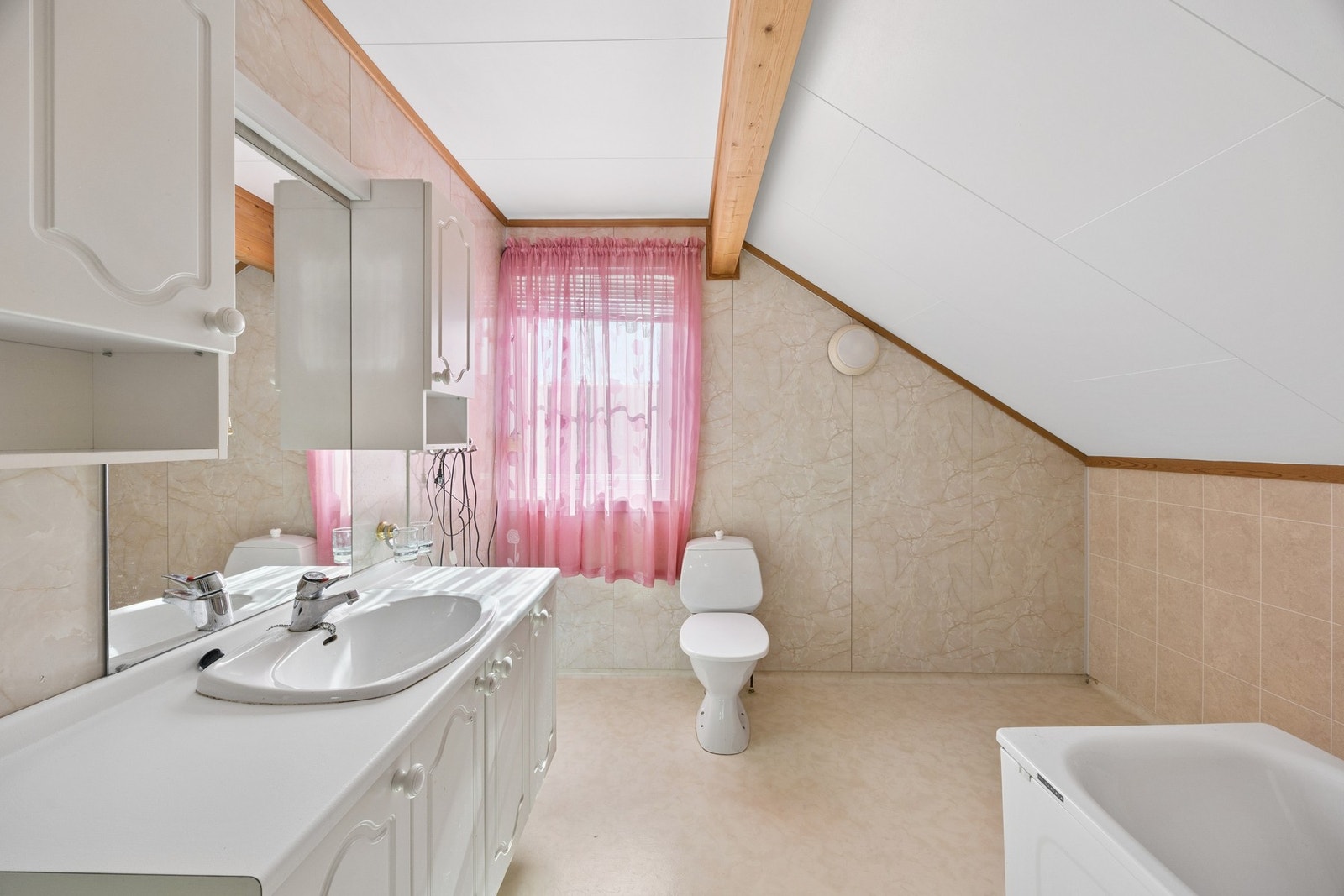 Badet på loftet er innredet med badekar, toalett og servant i innredning. Galleribilde