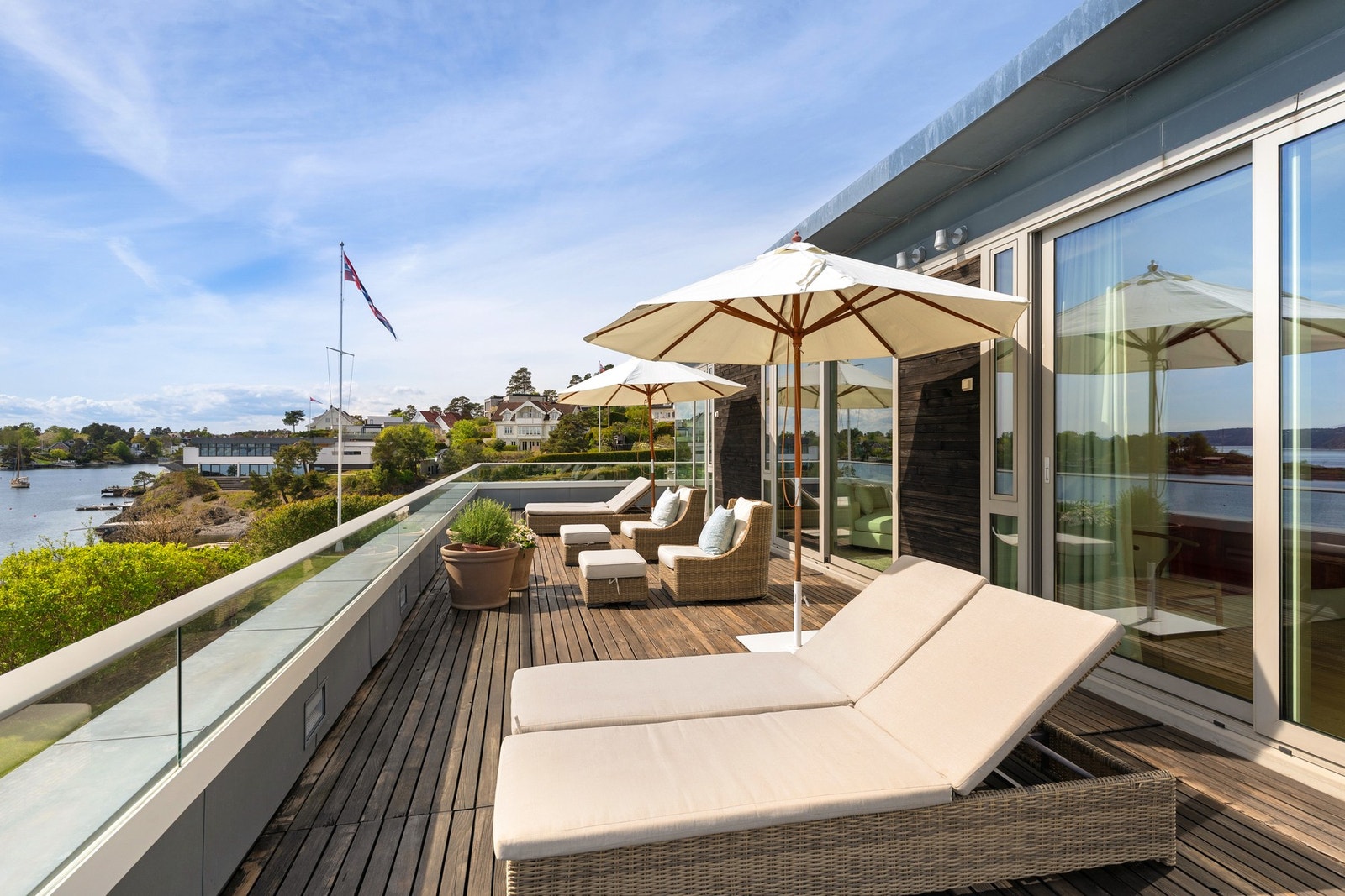 Terrassen har glassrekkverk på inntekket brystning og impregnerte terrassebord med underliggende membrantekking. Galleribilde