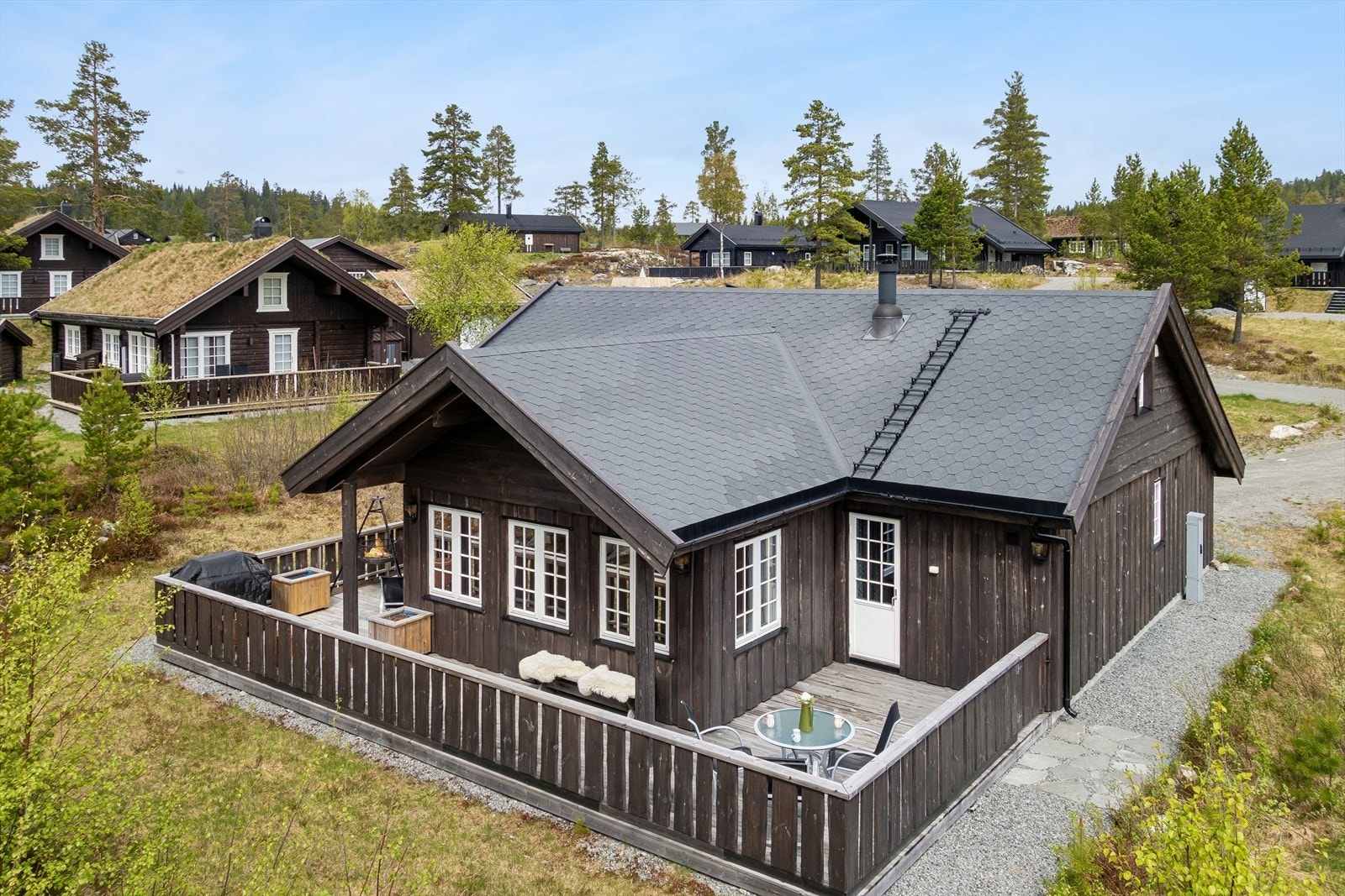 Moderne fritidsbolig fra 2018 med kledning i villmarkspanel og en romslig garasje på 41 m² oppført i 2023. Galleribilde