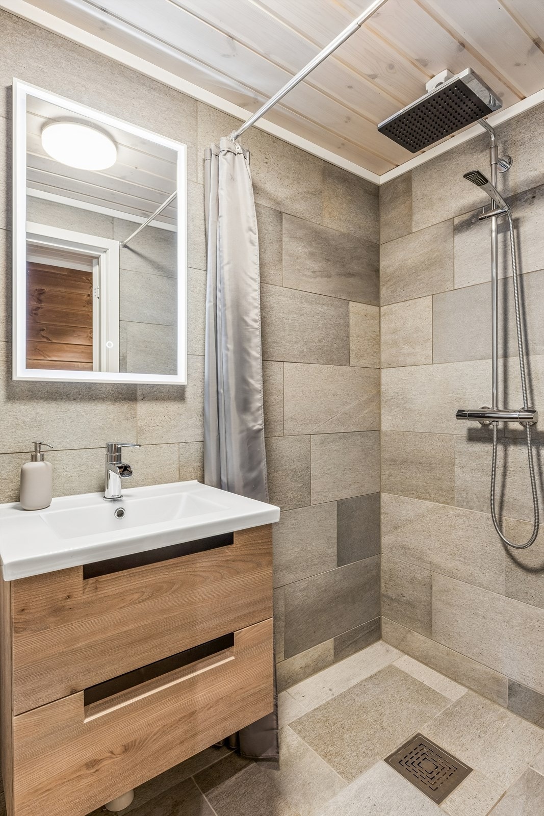 Badet har dusjnisje og elektrisk styrt vifte for god ventilasjon. Galleribilde