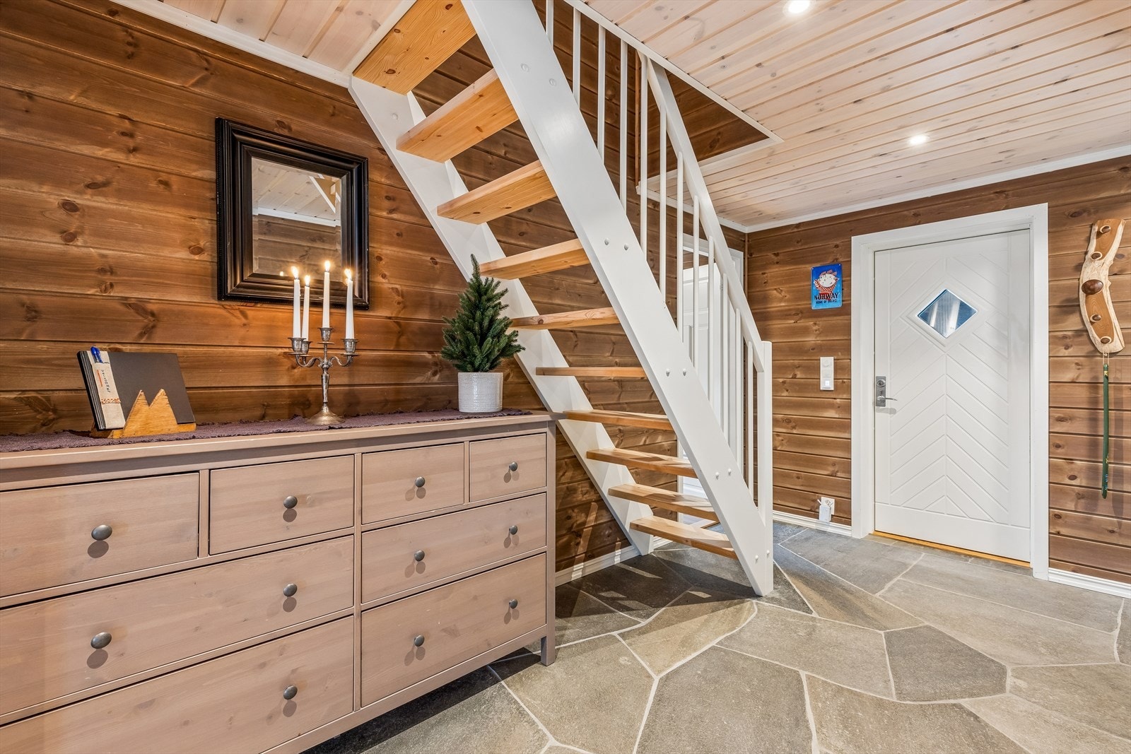 Fra gangen leder en tretrapp med åpne trinn opp til hemsen. Galleribilde