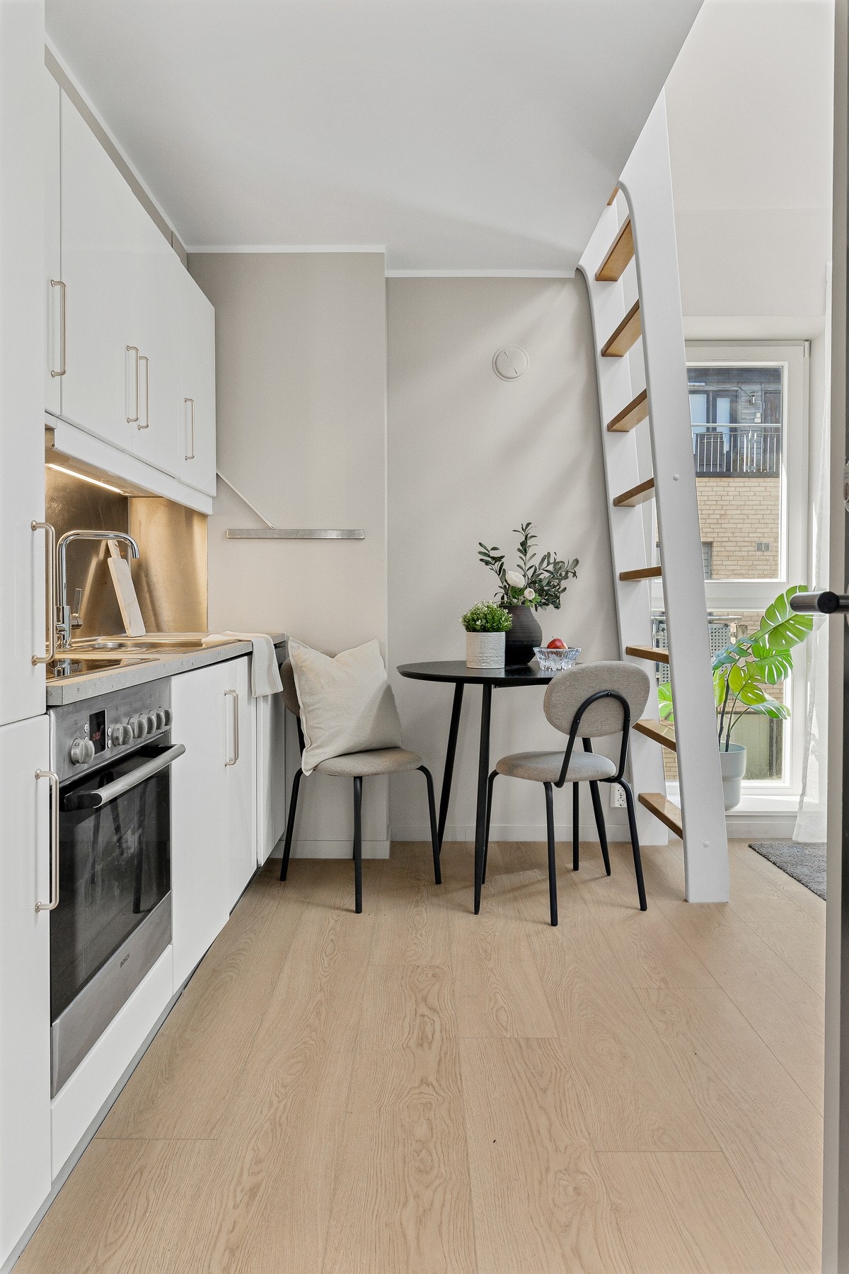 Det er integrerte hvitevarer og innredningen er smakfull hvit, med slette fronter og laminat benkeplate Galleribilde