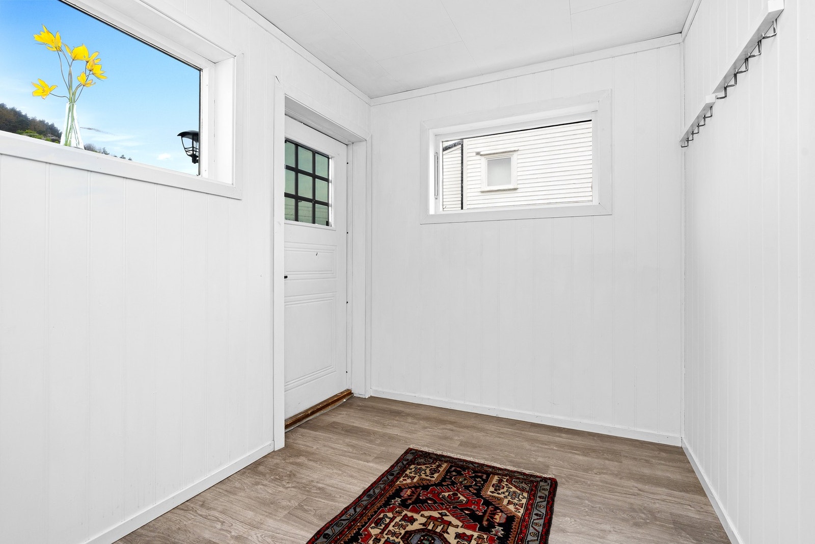 Lyst og romslig inngangsparti med store vinduer og lysmalte vegger. Galleribilde