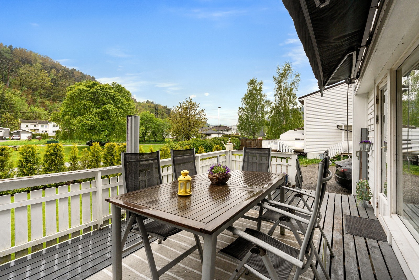 Terrasse med utsikt mot grøntområde og nærliggende boliger. Galleribilde