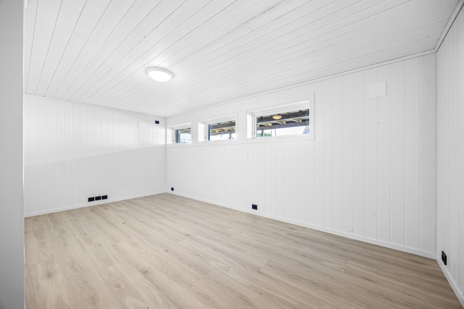 Oppusset kjellerstue med nytt elektrisk, laminatgulv og panel på veggene. Et allsidig rom, godkjent som hobbyrom i byggemeldte tegninger. Galleribilde