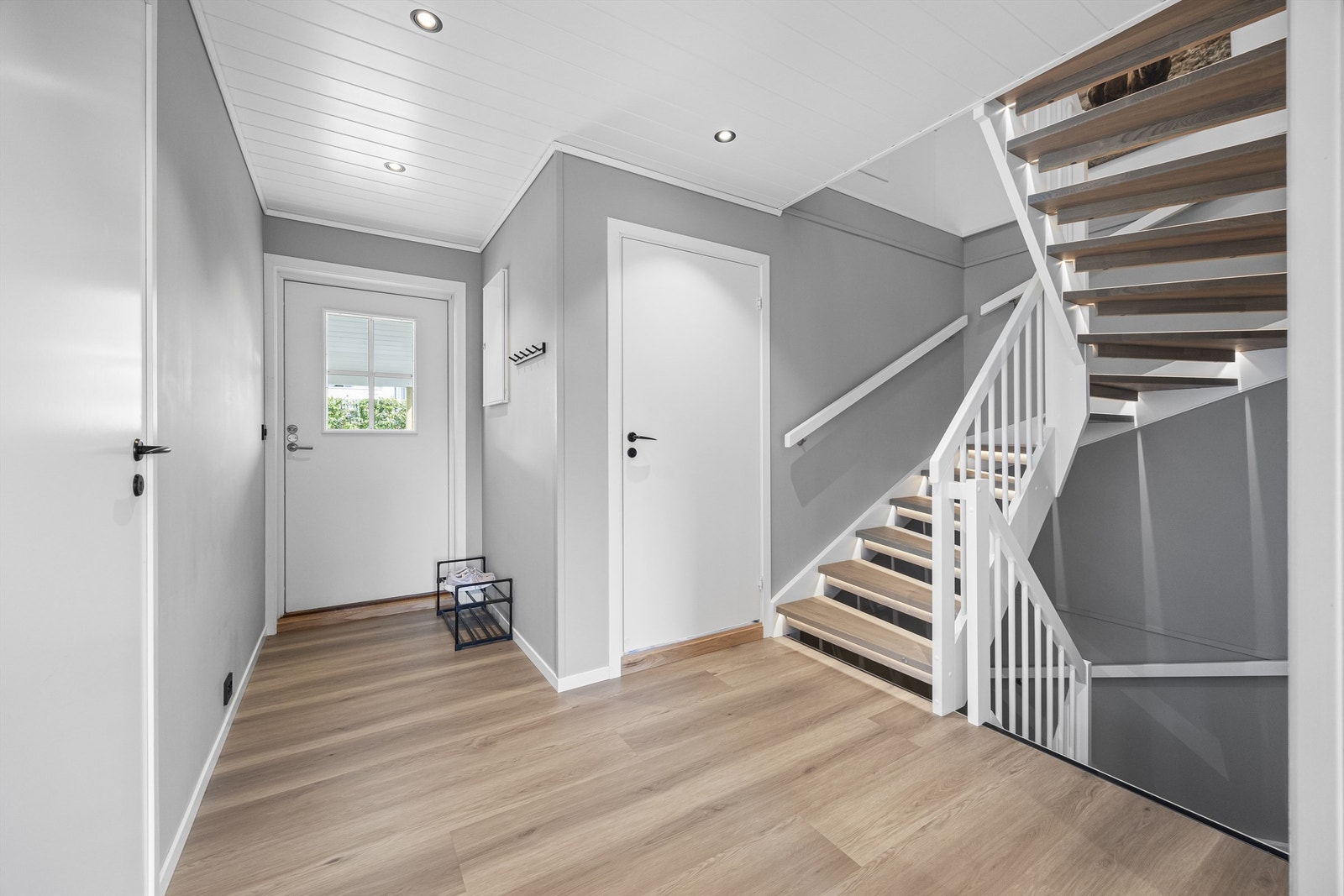Lys entré med trapp til loft og kjeller. Laminatgulv og malte flater er gjennomgående i etasjen og fornyet i nyere tid. Galleribilde