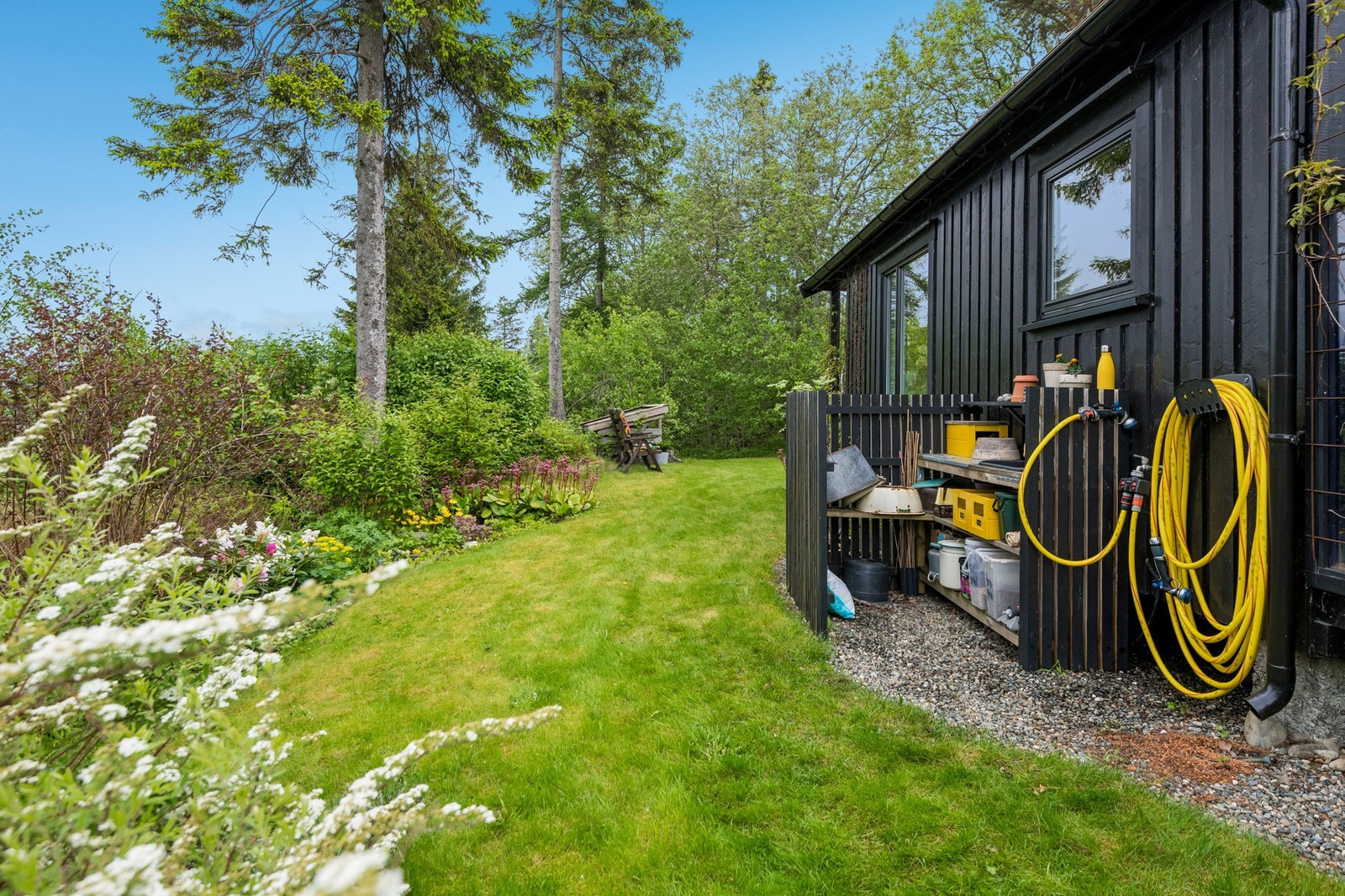 På nedsiden av hytta er det et praktisk utekjøkken med vann på yttervegg. Galleribilde