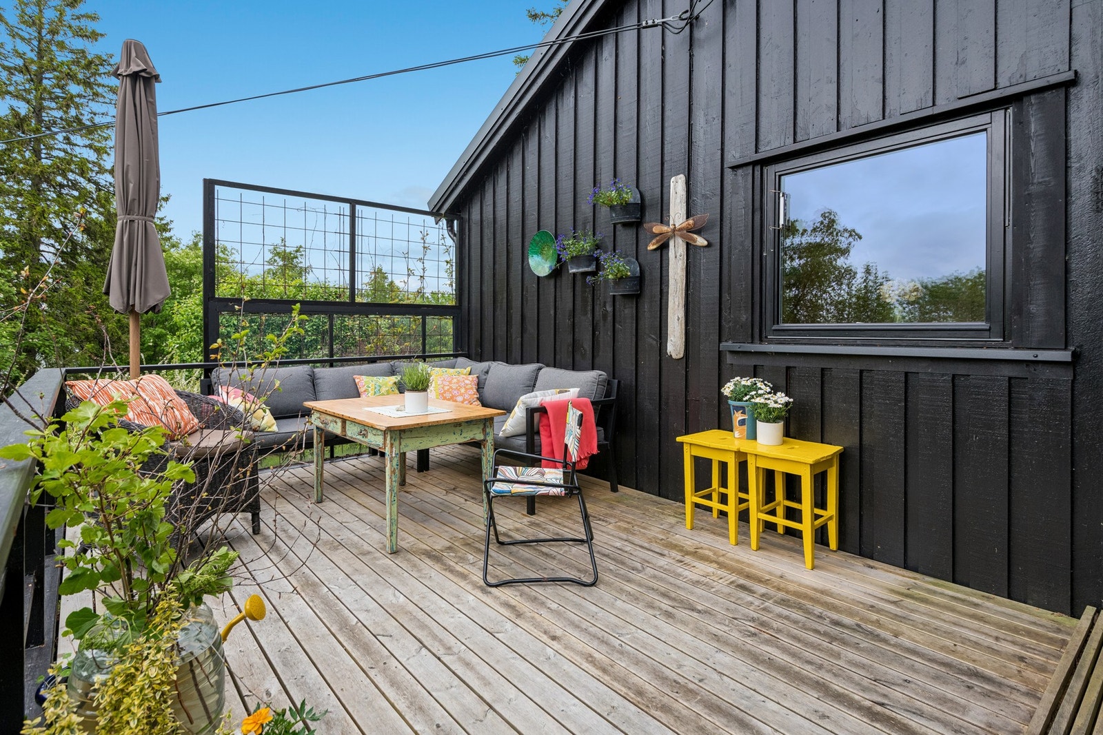 Romslig veranda med god plass til hagemøbler og grill. Her kan man nyte godt av kveldssola utover fine sommerkvelder. Galleribilde