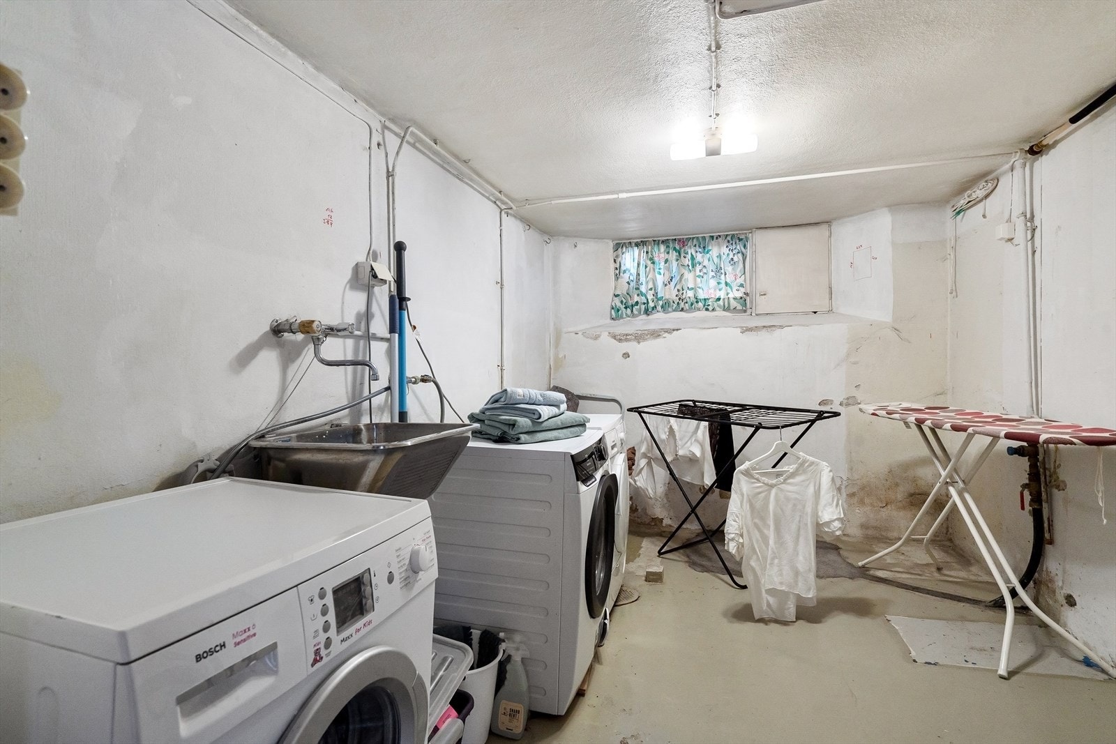 Praktisk vaskerom i kjelleren med opplegg for vaskemaskin og god plass til tørkestativ. Galleribilde