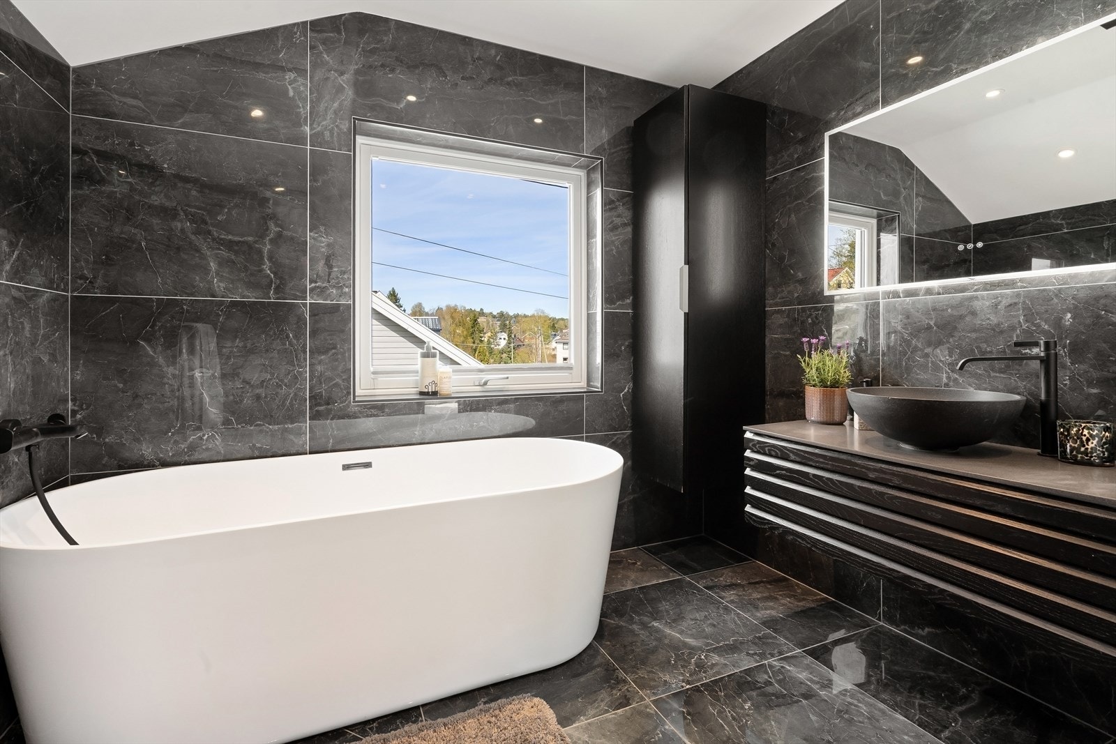 Badet er romslig med både frittstående badekar og god skapplass. Galleribilde