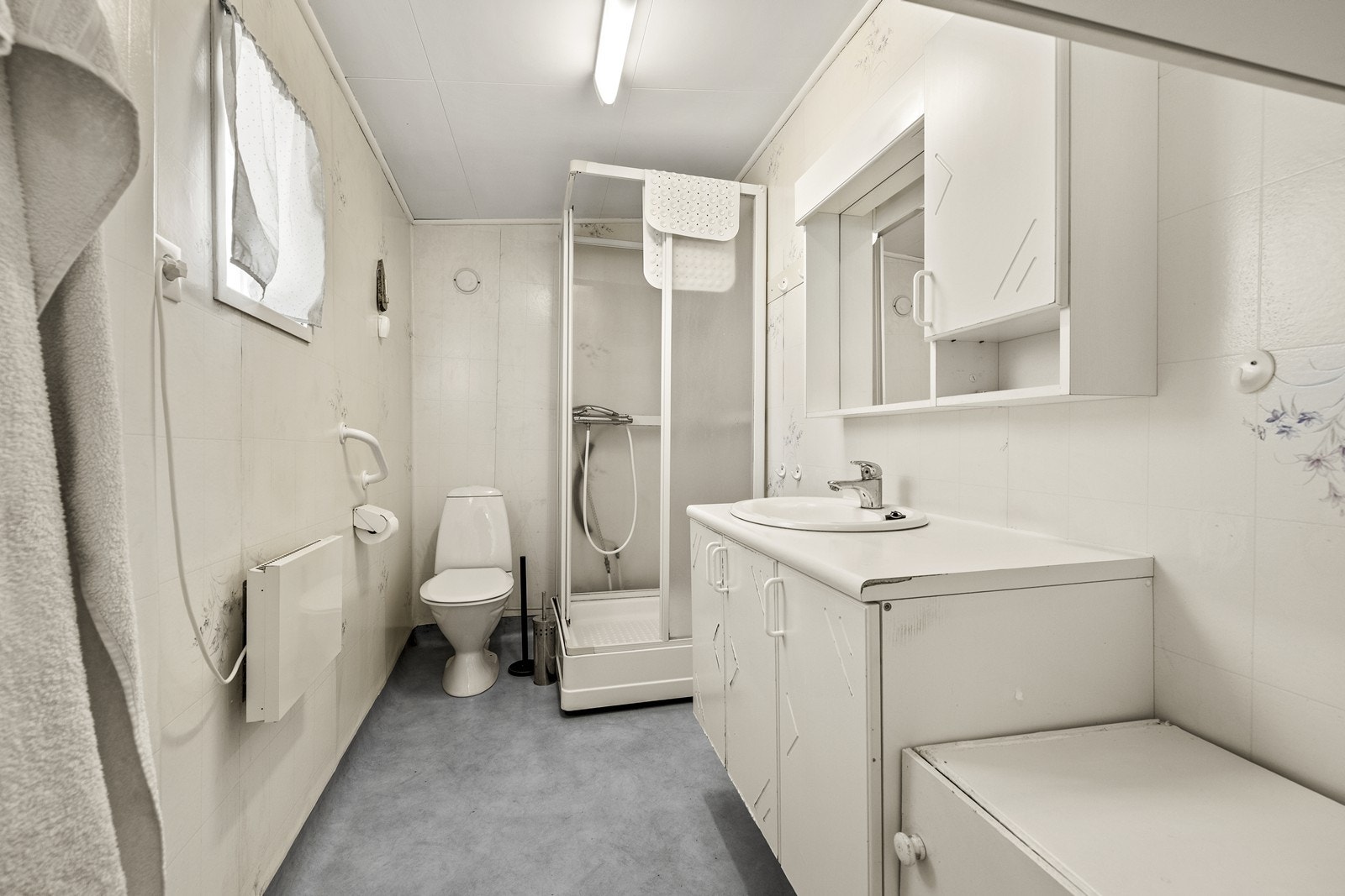 Badet er utstyrt med dusjkabinett, toalett og servantinnredning med speilskap. Galleribilde