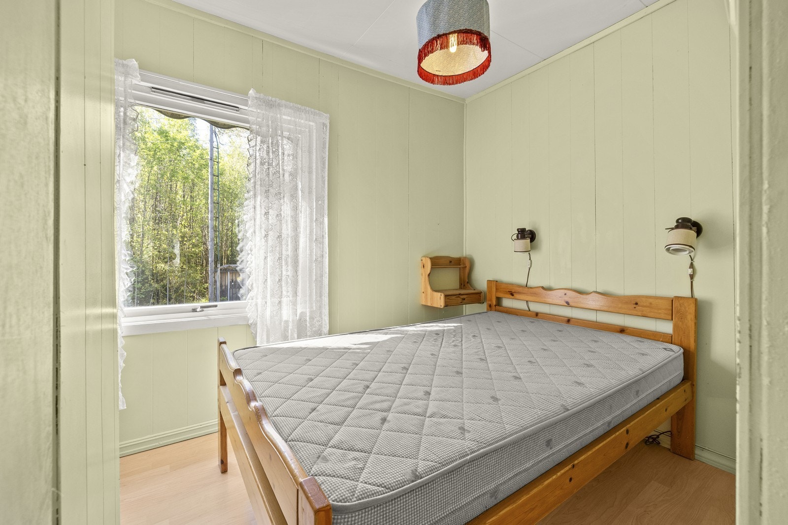 Soverom med plass til dobbeltseng. Vegger med malt trepanel. Galleribilde