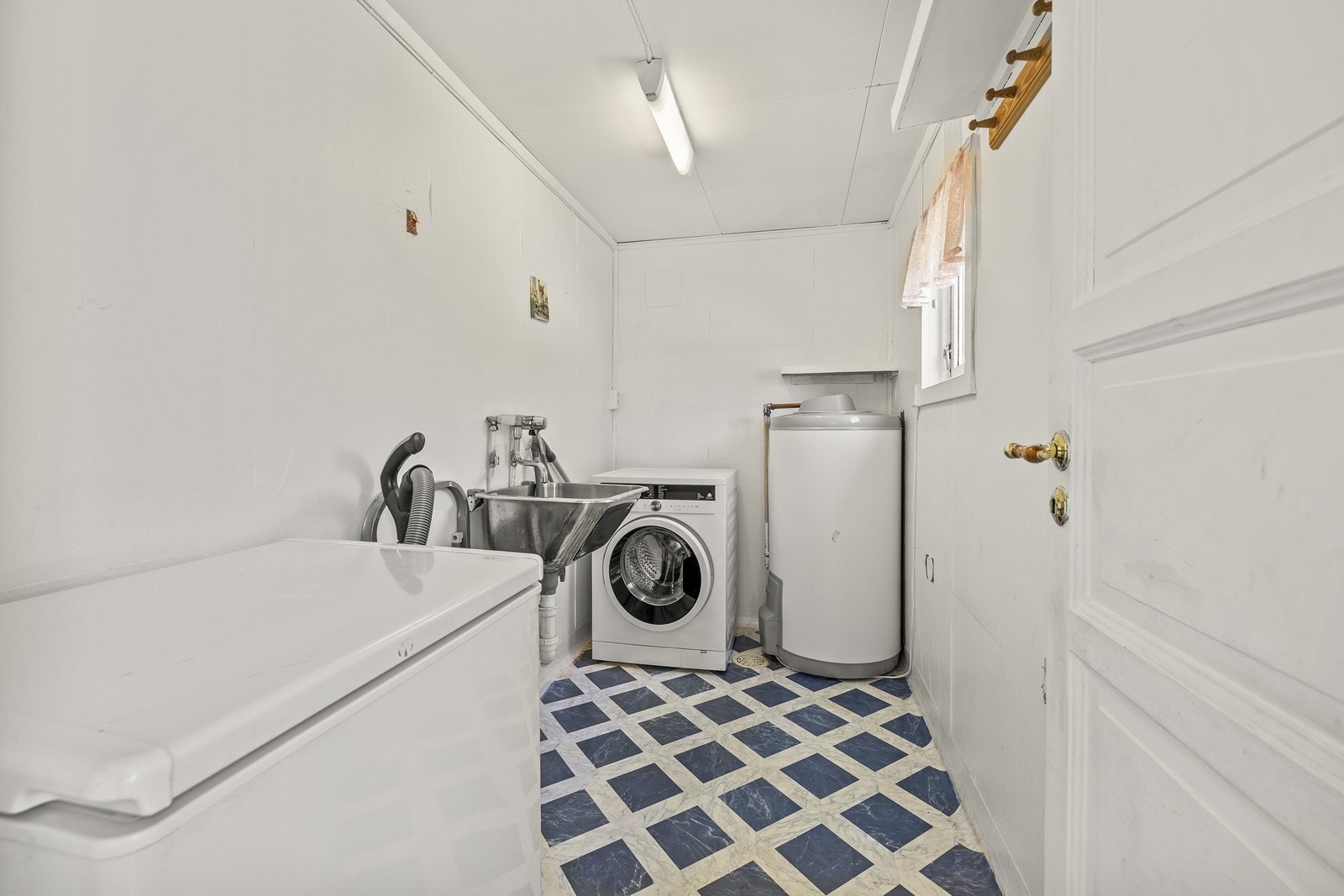 Praktisk vaskerom med opplegg for vaskemaskin, utslagsvask og en 190-liters varmtvannsbereder fra 2019. Galleribilde