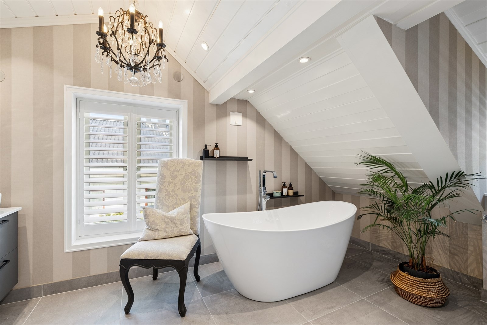 Badet er elegant innredet med frittstående badekar, downlights og malt panel i himlingen. Galleribilde