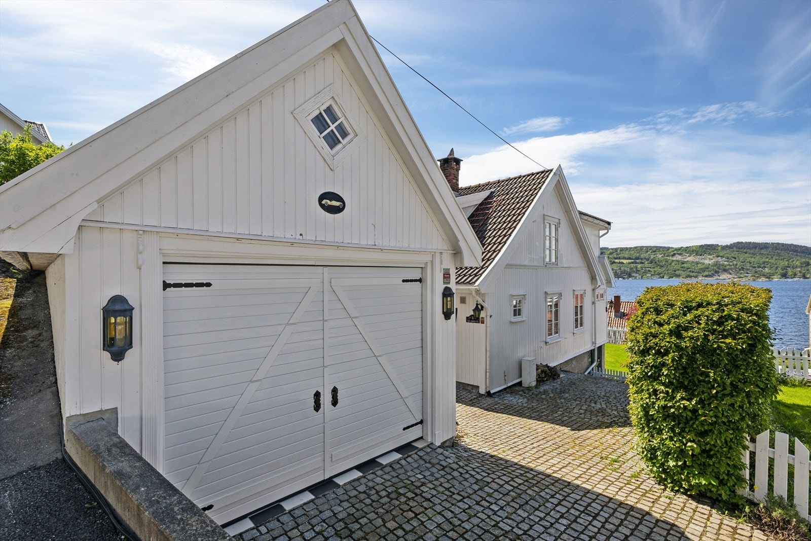 Frittliggende garasje fra 1996 med motorisert leddport (ny 2025) og snøsmelteanlegg i innkjørselen. Galleribilde