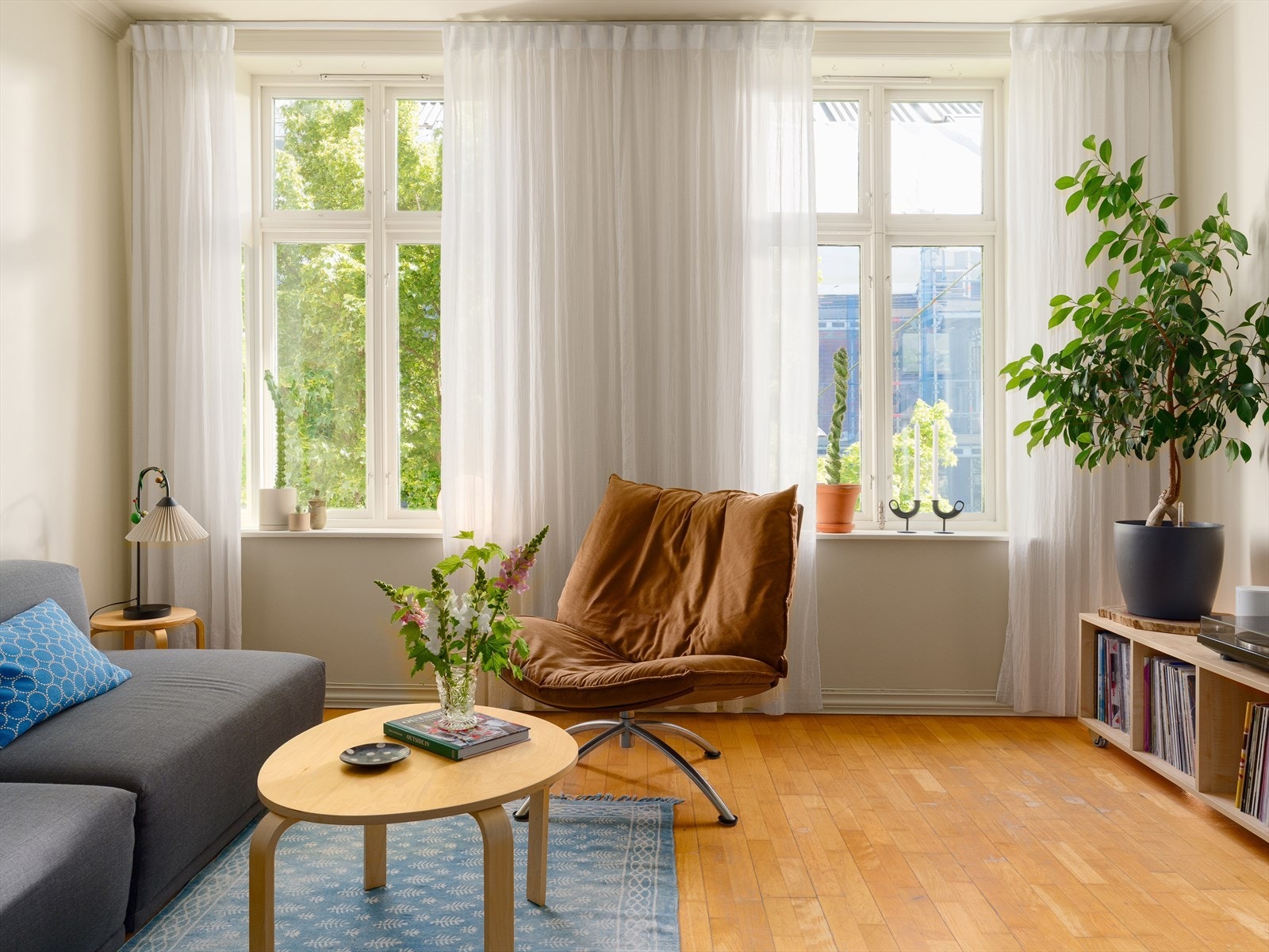 Store vindusflater på rekke og rad slipper inn rikelig med naturlig lys, og bidrar til en harmonisk og luftig atmosfære i leiligheten. Galleribilde