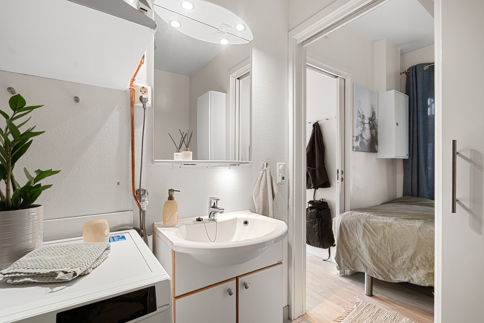 Badet er utstyrt med servant i skap og opplegg for vaskemaskin. Galleribilde