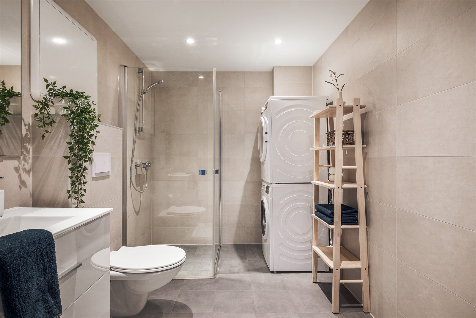 Badet er moderne utformet med fliser på både gulv og vegger, innfelte downlights og gulvvarme som gir ekstra komfort. Her får du en funksjonell hverdagsluksus med det lille ekstra. Galleribilde