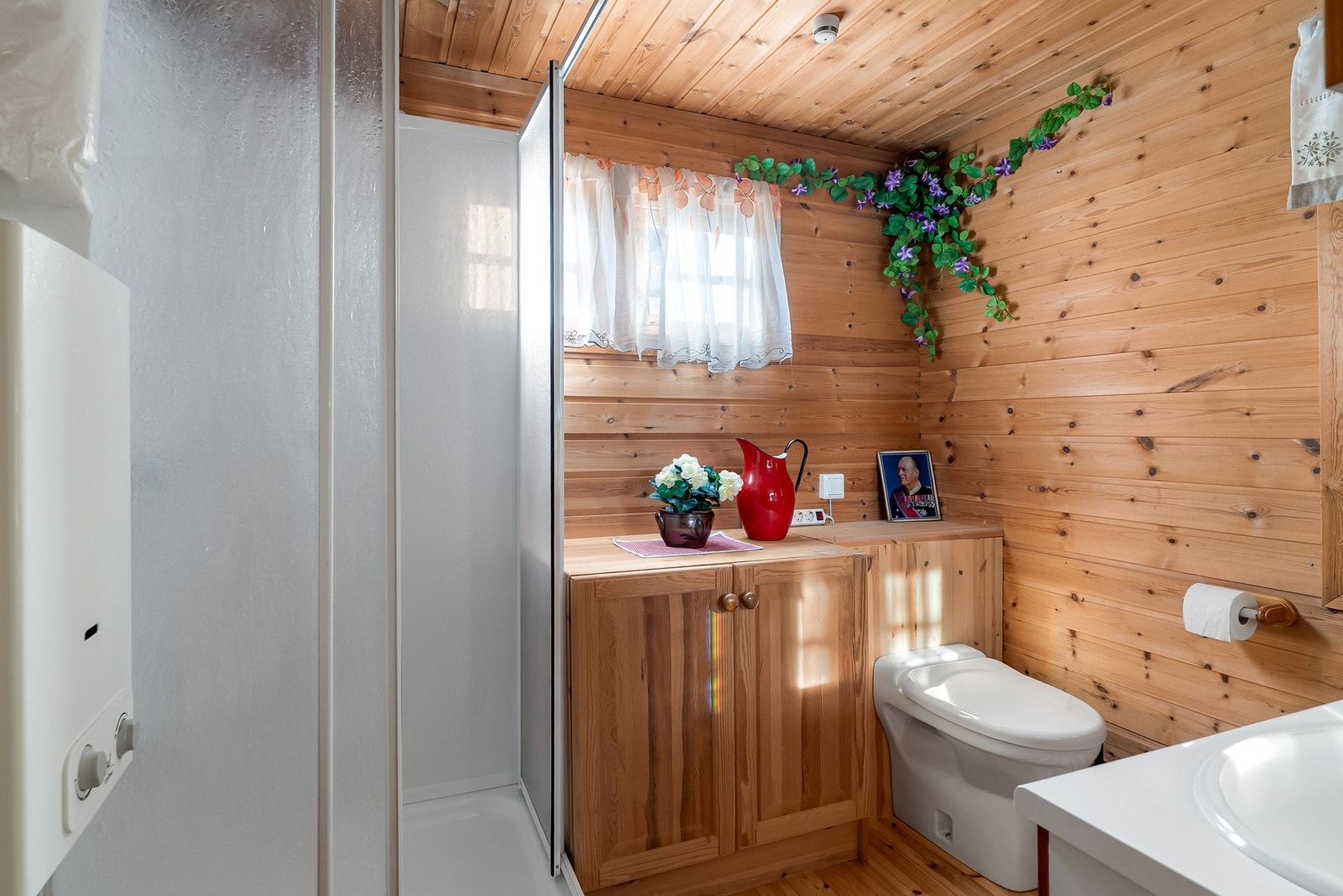 Badet er innredet med toalett, dusjkabinett. Gassoppvarmer for varmtvann til dusjen. Galleribilde