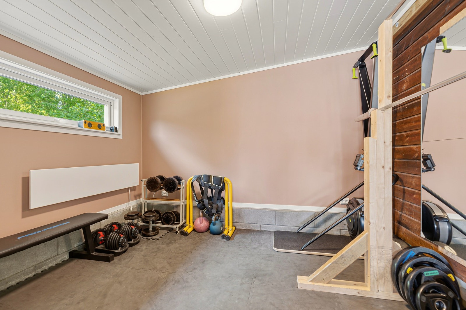 Det er innredet treningsrom i bodrommet på innsiden av carporten. Rommet er delvis isolert og kan fint brukes hele året Galleribilde