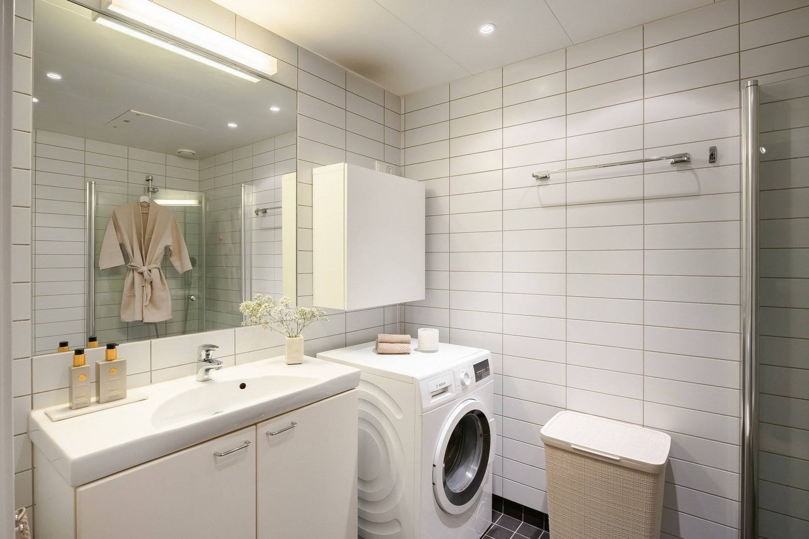 Badet for øvrig inneholder bl.a. dusjhjørne m/ innfellbare dører, servant med underskap, vegghengt toalett og opplegg for vaskemaskin. Galleribilde